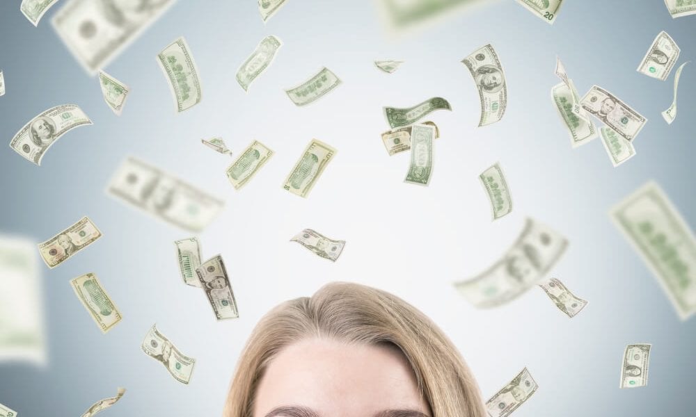 Paper money falling around a women's head